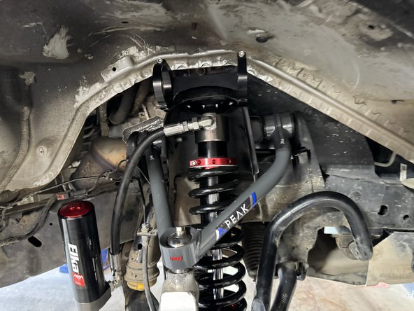 Install the Elka shocks using provided lower bolts and the provided upper bolts. Hoses must face the rear of vehicle as shown (right side shown).