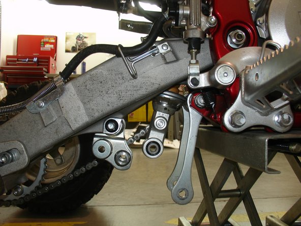 Remove the linkage bolt and the upper  shock bolt.