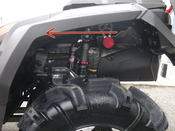 Install the left new Elka rear shock with the piggyback reservoir at the top and oriented towards the front of the vehicle as indicated by the red Arrow on the photo.