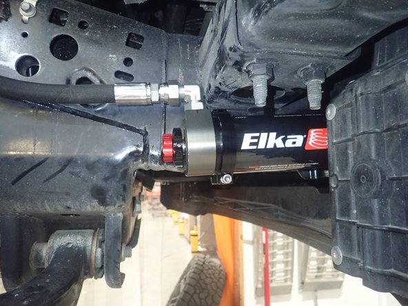 Sit the reservoir into the bracket clamps, then place the reservoir in such a way as to place the hose properly. BE CAREFUL TO NOT OVERBEND THE HOSE OR CREATE RUBBING ON FRAME.