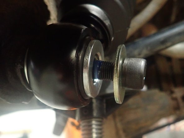 Use supplied longer bolt and washer to fix lower eyelet. Apply thread locker on bolt's threads then torque it at 60 Ft-Lb.