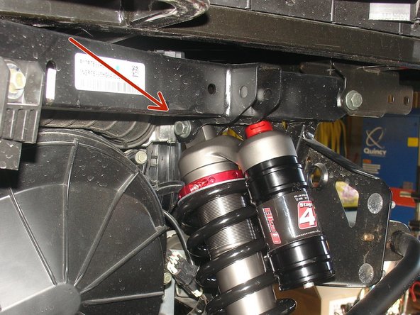 The upper bolt of shock must be installed in the inner frame hole as shown by red Arrow.
