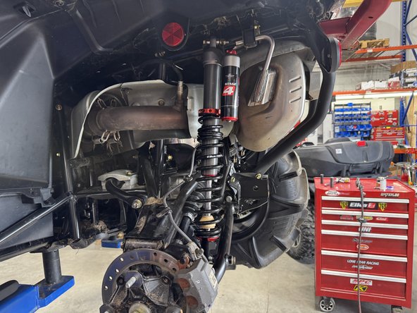 Install the left new Elka rear shock with the piggyback reservoir at the top and oriented towards the rear of the vehicle.