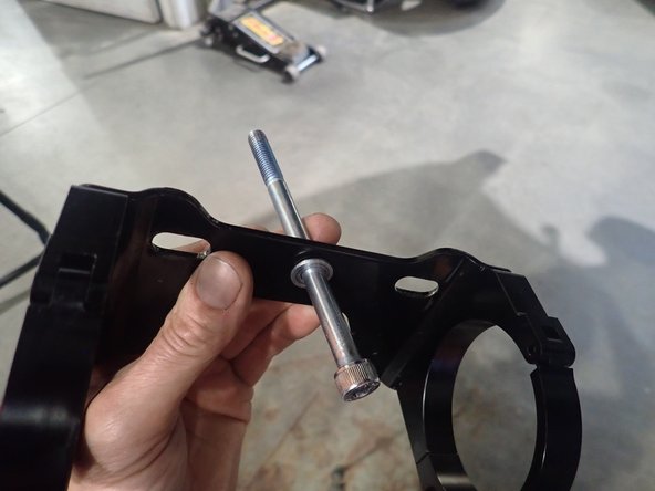 DRIVER SIDE: Slide the small washer on the long 8mm bolt. Insert bolt in the CENTER HOLE of the bracket assembly.