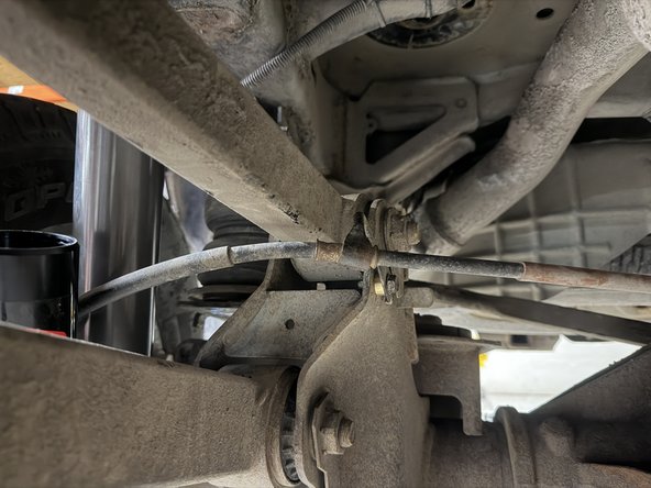 Install the longer spacer on the rear right side as shown to offset the handbrake cable. Make sure that the cable does not touch the reservoir.