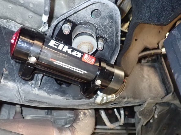 Sit the reservoir into bracket's clamps as shown. Place reservoir to have the hose close to the frame without interferences. (Right side shown)