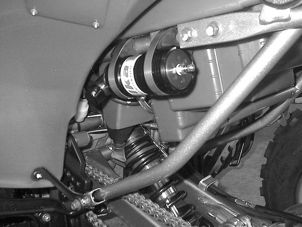 The rear reservoir must be attached to the rear sub-frame on the left side of the quad, right underneath the fender. Compression knob must face towards outside of the quad.