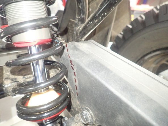 To avoid contact with the spring, trim chain guard as shown.