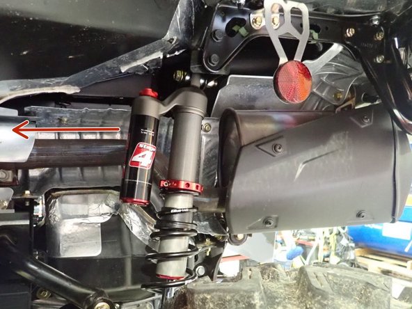 Install the left new Elka rear shock with the piggyback reservoir at the top and oriented towards the front of the vehicle as indicated by the red Arrow on the photo.