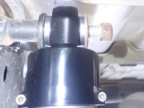 Using oem washer and nut, apply threads locker then torque upper nut at 50 Ft-Lb.