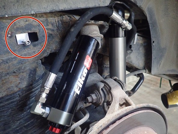 Screw the rectangular piece only a few turns in the center of the bracket as shown, then apply threadslocker on screw threads.