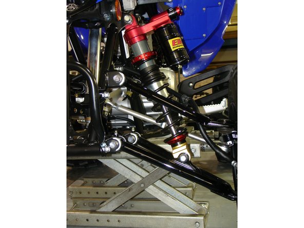 Install the Elka shock absorbers with the piggyback reservoirs towards the top and the adjustment knobs towards the outside of the quad. Make sure the rebound adjuster screw (if such equipped) is facing towards the inside of the quad. Tighten the top mounting bolt then the lower mounting bolt.