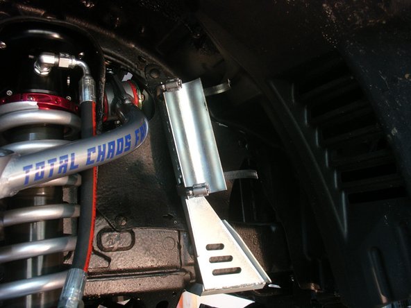 For Elka shocks without réservoir, use supplied rectangular spacers to move the sway bar forward. Use the spacer with an "L" on left side, with the arrow pointing forward the vehicle. Do the same with the "R" spacer on the right side.