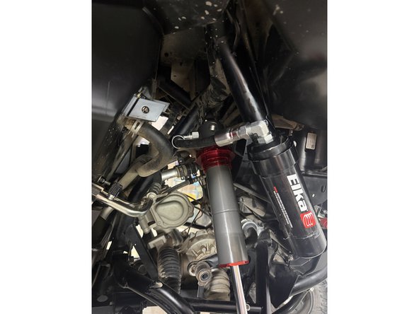 Note: The hose configurations differ between the left and right sides. Refer to the images to ensure the shocks are installed on the correct side. Right side shown.