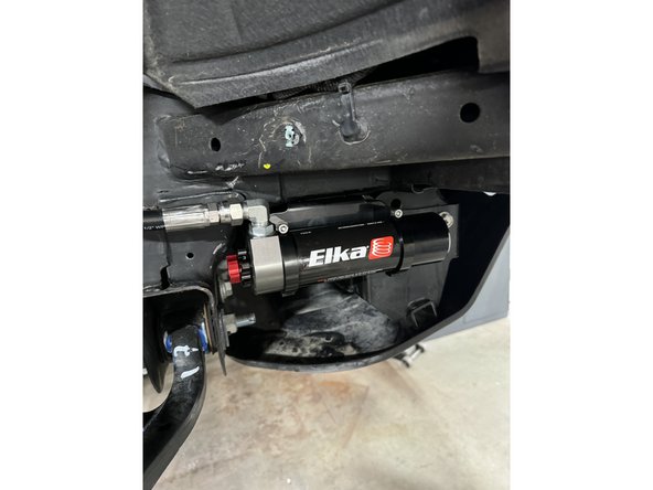 Sit reservoir into bracket's clamps, then place the reservoir in a way to place reservoir fitting and hoses as close to the frame as possible, without touching it. BE CAREFUL TO NOT OVERBEND THE HOSE OR MAKE THE HOSE RUBBING ON SUSPENSION COMPONENTS.