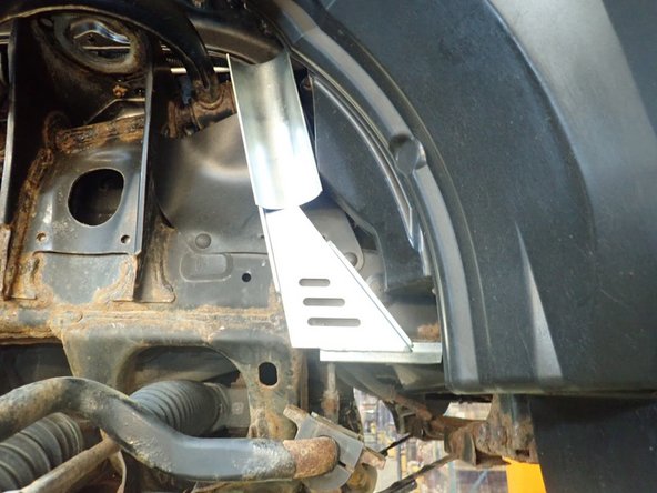 With the longer supplied bolts, and using counter bore holes, fix the reservoir brackets in the sway bar mounting holes (right side shown).