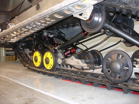 Install the Elka rear shock with the reservoir at the bottom and oriented towards the rear of the snowmobile as shown on the photo.