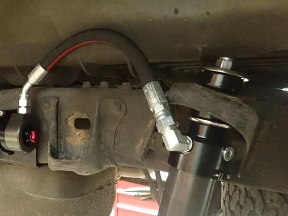 Hose fitting must face rear of vehicle on right side, and face the front of vehicle on left side.