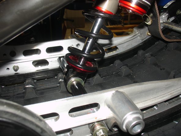 The lower shock eyelet rebound adjuster screw must be oriented toward the rear of vehicle,