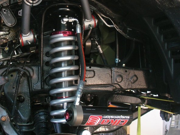 Install Elka shocks with the hose fitting facing front of vehicle. (right side shown)