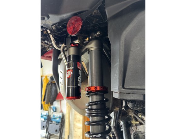 Install the right new Elka rear shock with the piggyback reservoir at the top and oriented towards the rear of the vehicle.