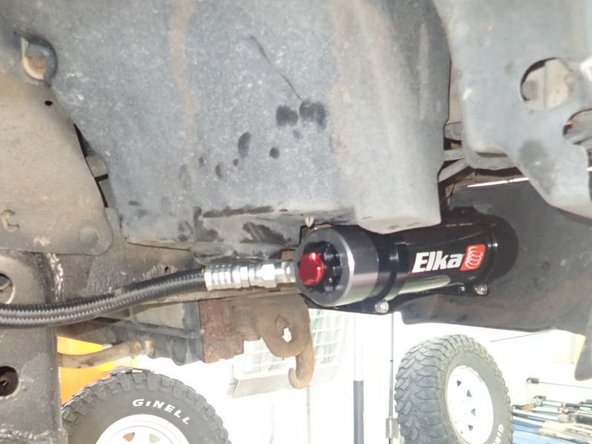 Sit reservoir into bracket's clamps, then place the reservoir in a way to place hose properly. BE CAREFUL TO NOT OVERBEND THE HOSE