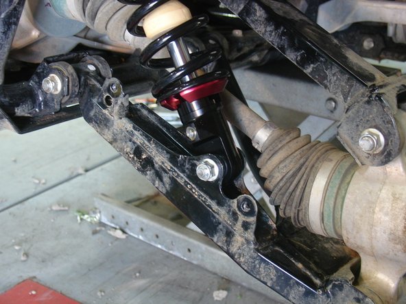 On Stage 2, Stage 4, and Stage 5 models the rebound adjuster located on lower eyelet of the shocks should be oriented towards the rear of the vehicle, as shown. (Right side shown ). If needed, you can turn the lower eyelet to orient properly.