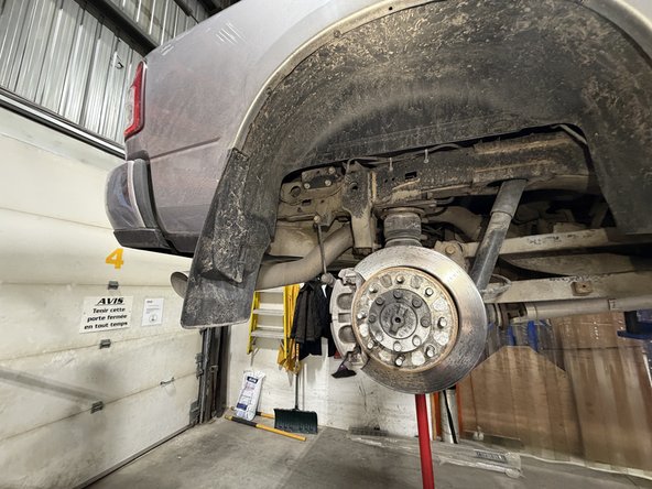 Lift the vehicle using a jack or stand so that the front shocks are in fully extend position WITHOUT TAKING WHEELS OF THE GROUND or HOLDING AXLE WITH STAND The shocks hold the front axle, so be sure the axle can't fall before removing front shocks.