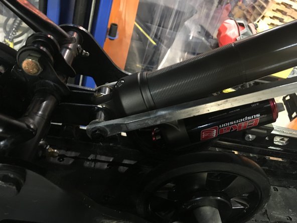 Install the Elka rear shock with the reservoir facing down and oriented towards the rear of the snowmobile as shown on the photo