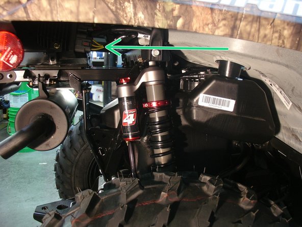 Install the right new Elka rear shock with the piggyback reservoir at the top and oriented towards the rear of the vehicle as indicated by the green Arrow on the photo.