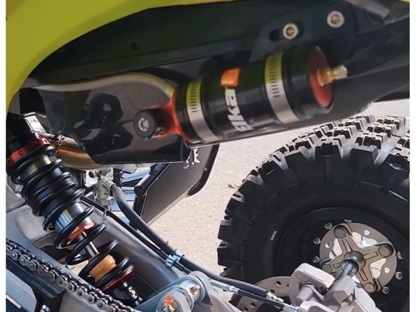 Install shock with the hose fitting on the front side of atv, and pointing left of atv.