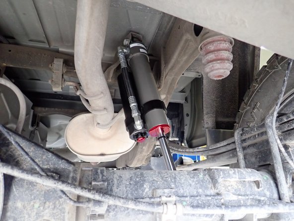 RIGHT SIDE: Install rear right shock with head to the top and reservoir facing front of vehicle as shown.