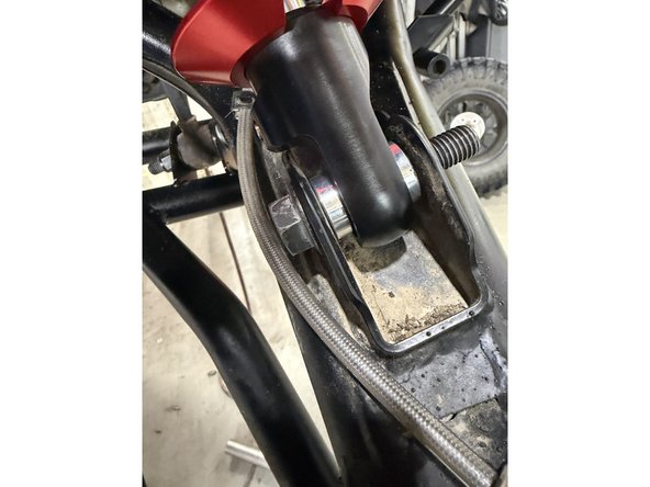 Note: The hose configurations differ between the left and right sides. Refer to the images to ensure the shocks are installed on the correct side. Right side shown.