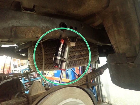 Slide shock's upper mount on stud. Using oem washer and nut, torque upper mount at 40 Ft-Lb.