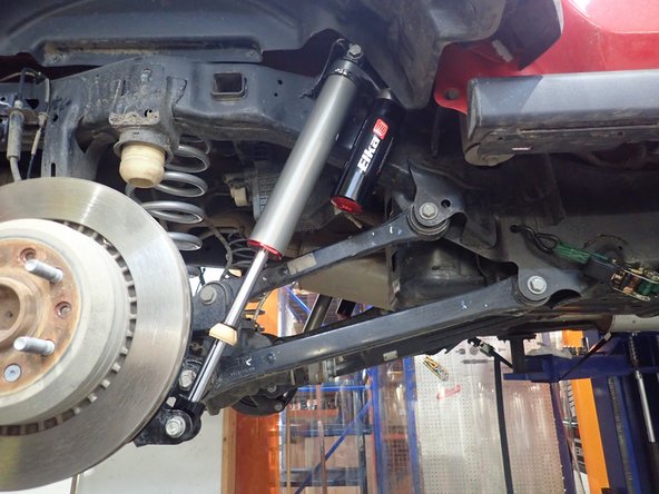 Install new Elka rear shocks with the reservoir upside and facing the front of vehicle. (Right side shown).