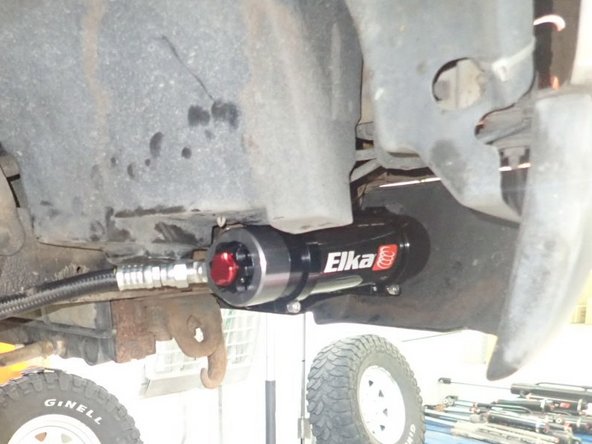 Sit reservoir into bracket's clamps, then place the reservoir in a way to place hose properly. BE CAREFUL TO NOT OVERBEND THE HOSE.