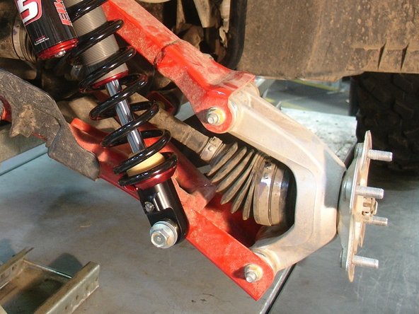 On Stage 2, Stage 4, and Stage 5 models the rebound adjuster located on lower eyelet of the shocks should be oriented towards the rear of the vehicle, as shown. (right side shown ). If needed, you can turn the lower eyelet to orient properly.