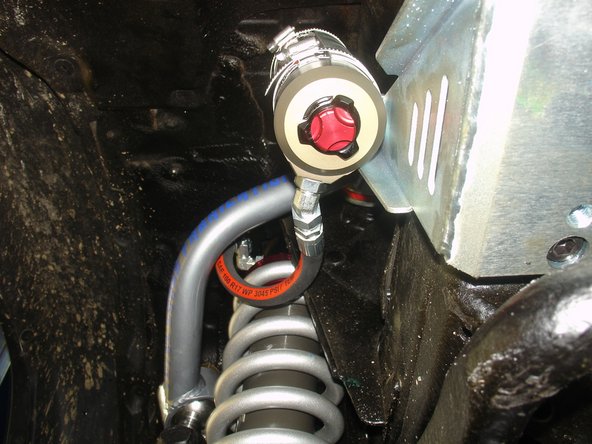 Sit the reservoir into bracket, locating it as high as possible while aligning the hose as close to the chassis possible.