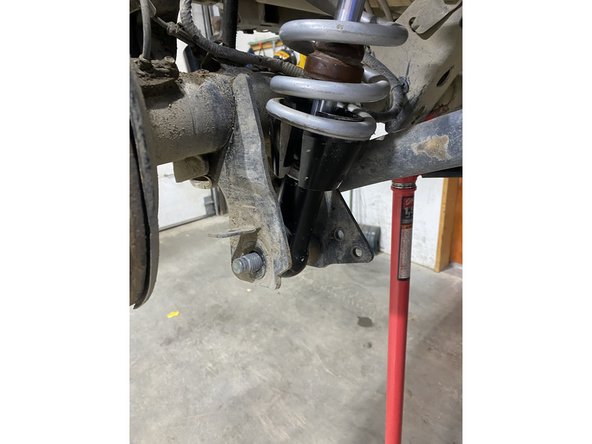 install the lower bolt of the shock .