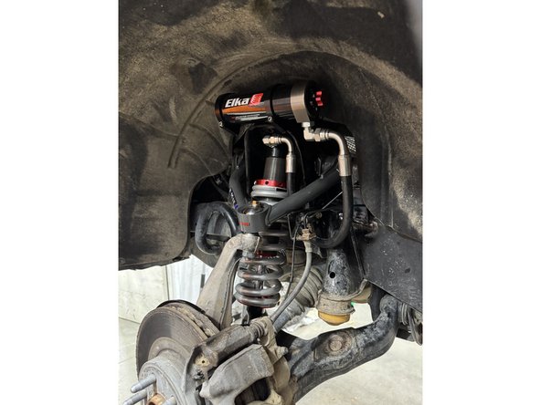 Sit the reservoir into the bracket clamps, then place the reservoir in such a way as to place the hose properly. BE CAREFUL TO NOT OVERBEND THE HOSE OR CREATE RUBBING ON FRAME.