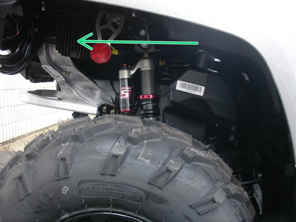 Install the right new Elka rear shock with the piggyback reservoir at the top and oriented towards the rear of the vehicle as indicated by the green Arrow on the photo