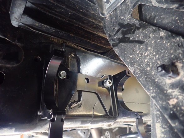 Fix the bracket in place using the 8mm  bolt in the rightmost bracket hole on right side, and leftmost hole on left side, orienting it as horizontally as possible. Use threads locker and torque the bracket bolt to 15 Ft-Lb. Use the supplied self-taping screw to secure the bracket in the bracket's hole facing the rear of the vehicle.