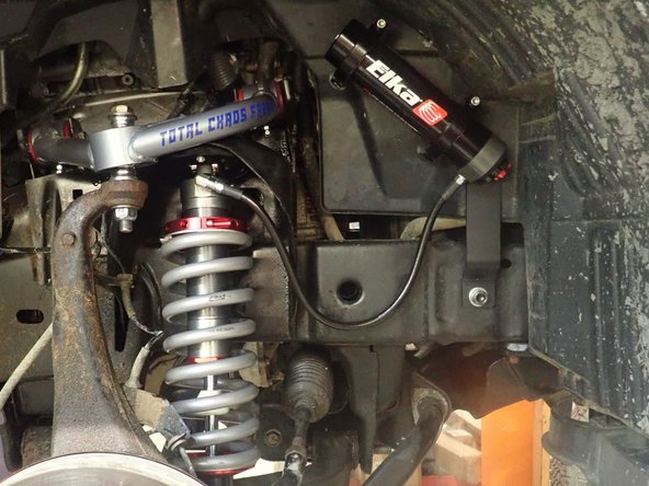 Sit reservoir into bracket's clamps, then place the reservoir in a way to place hose properly and closest to the frame possible. BE CAREFUL TO NOT OVERBEND THE HOSE OR MAKE IT RUBBING ON UPPER SHOCK MOUNT IN THE AREA SHOWED BY RED CIRCLE.