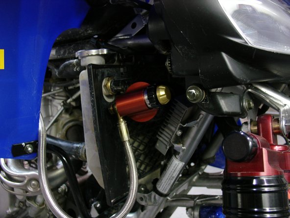 Install reservoir to the front of quad as shown.