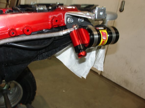 Install the rubber mount on the rear bracket and the reservoir with the angle as shown (install the rear fenders before tighten the rear reservoir).