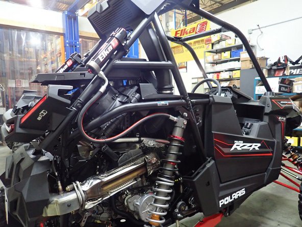 On Stage 2, Stage 4, and Stage 5 models the rebound adjuster located on lower eyelet of the shocks should be oriented towards the rear of the vehicle, as shown. (Right side shown ). If needed, you can turn the lower eyelet to orient properly.