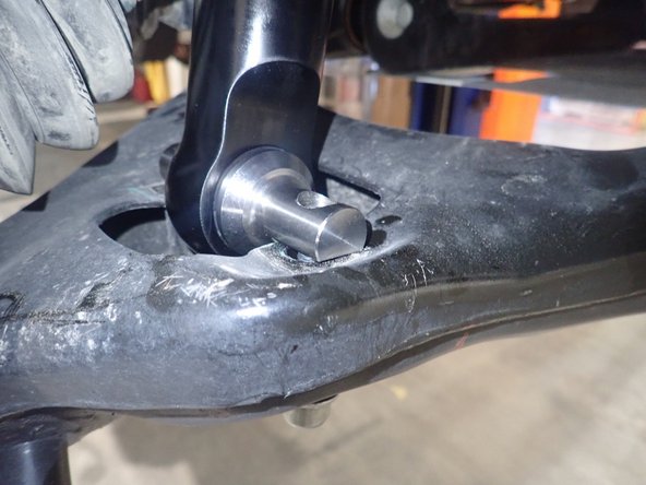 Make sure that the flat of the lower pin is against lower arm, as shown.