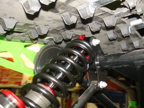 Lower the snowmobile completely and re-install the limiter strap.