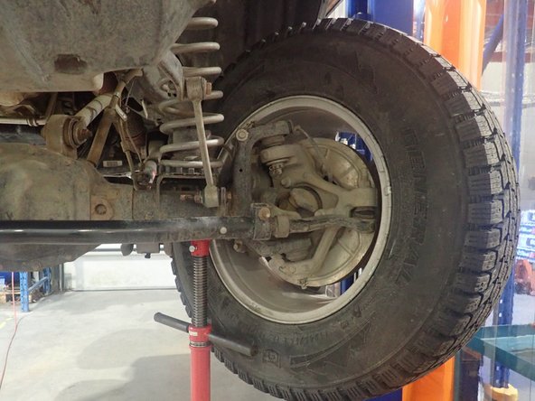 Lift the vehicle off the ground, then turn the wheels fully left. Make sure the left wheel steer stopper touch frame as shown by yellow circle