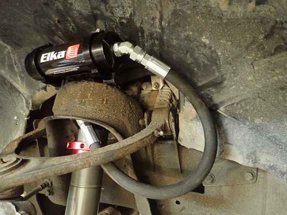 Reservoir's hose fitting must be closest to frame possible to force hose to go close to plastic fender..